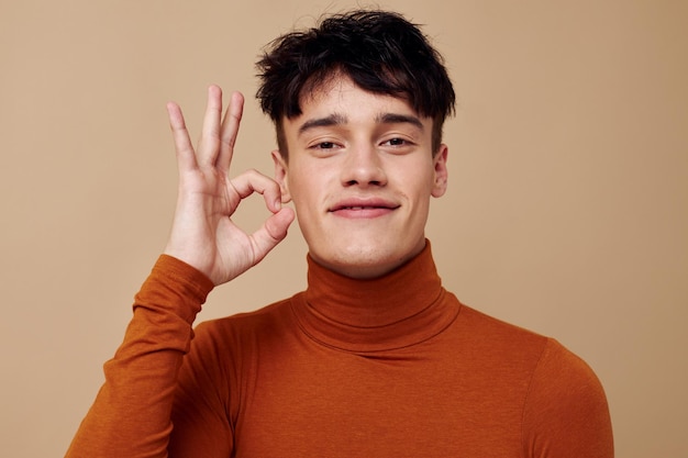 Handsome guy posing in brown sweater self confidence fashion isolated background unaltered