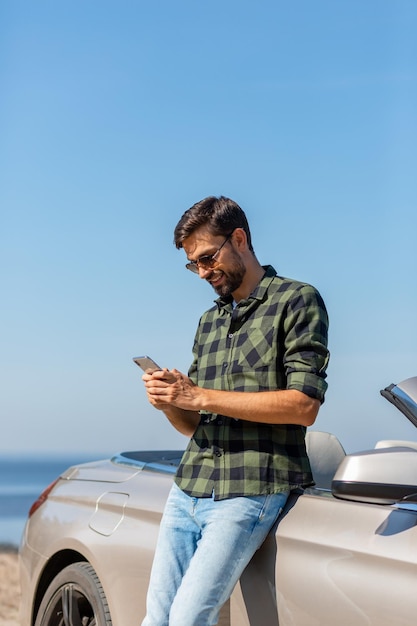 Handsome guy smiling while looking at the phone