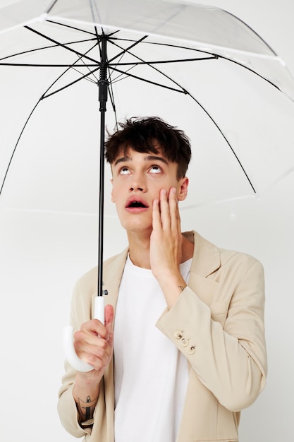 Handsome guy transparent umbrella a man in a light jacket isolated background unaltered