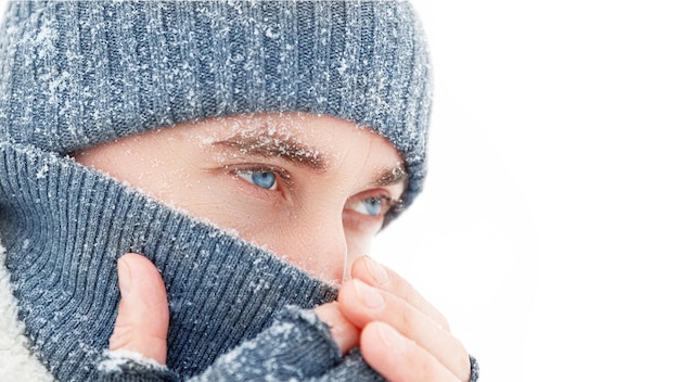 Handsome guy with blue eyes at the snow Winter portrait Copy space