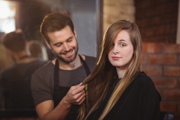 Handsome hair stylist with client