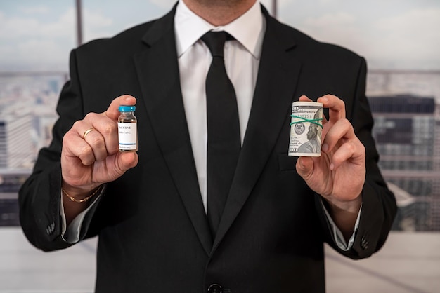 Handsome handsome man in a chic suit from a cool brand holds a vaccine and dollars