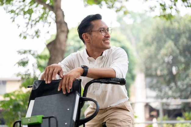 A handsome happy Asian millennial businessman is on a bike in the park riding a bike to work