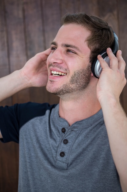 Handsome hipster listening to music with headphones