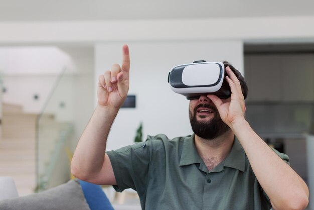 handsome hipster man with beard trying vr glasses at modern home