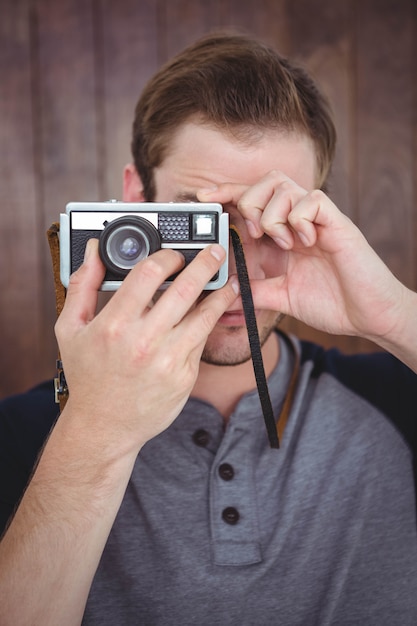 Handsome hipster taking picture with retro camera