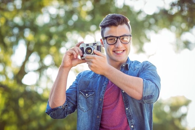 Handsome hipster using vintage camera