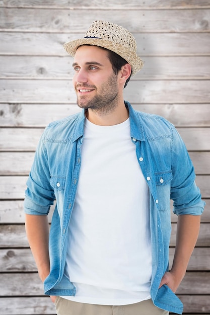 Handsome hipster wearing a trilby against wooden planks