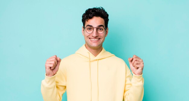 Handsome hispanic man feeling shocked excited and happy laughing and celebrating success saying wow