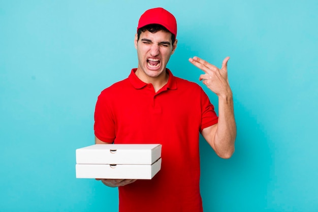 Handsome hispanic man looking unhappy and stressed suicide gesture making gun sign delivery pizza concept