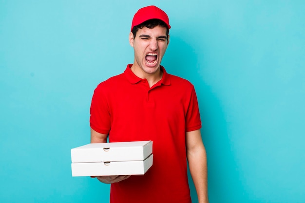 Handsome hispanic man shouting aggressively looking very angry delivery pizza concept