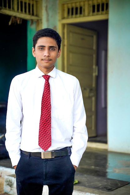 Handsome Indian young boy wearing white shirt and red tie