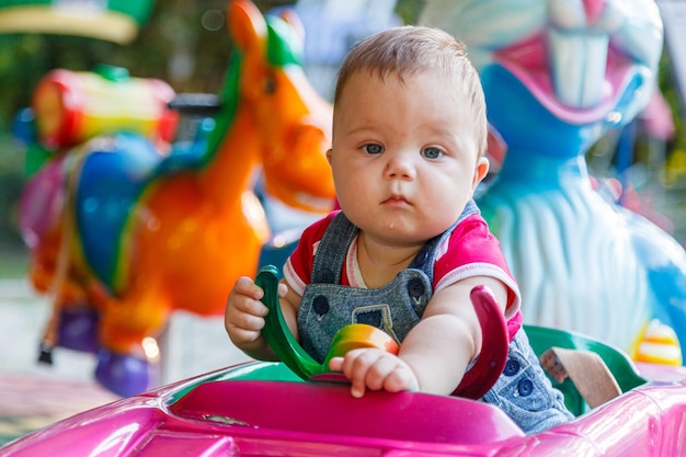 Handsome little boy on amusement ride machine