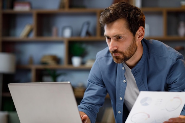 Handsome male businessman manager working behind a laptop in a stylish home office remote work at ho