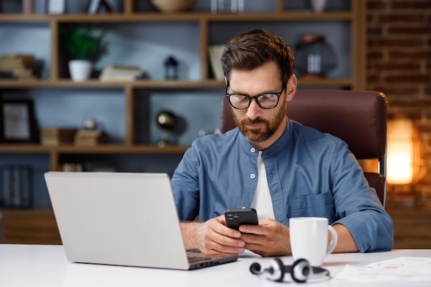 Handsome male businessman manager working behind a laptop in a stylish home office remote work at ho