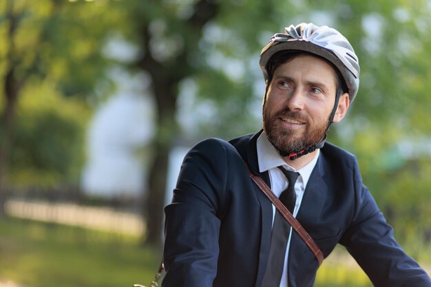 Handsome male businessman in protective helmet commuting at daytime