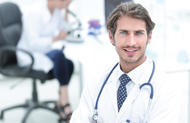 Handsome male doctor smiling with arms crossed on chest portrait