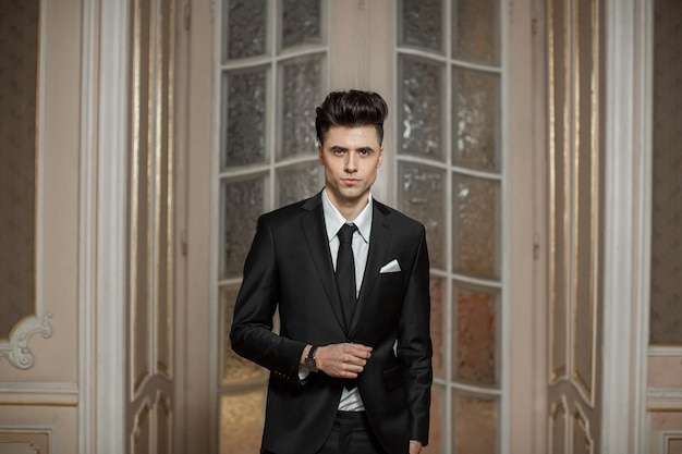 Handsome male model in a new suit in a beautiful room