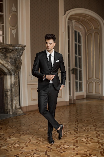 Handsome male model in a new suit in a beautiful room