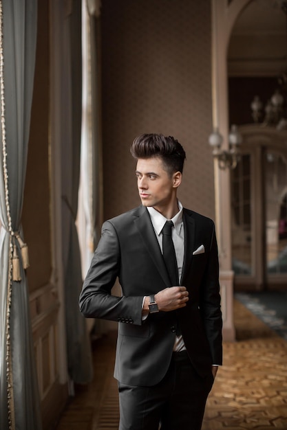 Handsome male model in a new suit in a beautiful room