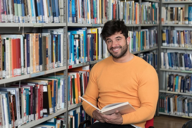 Handsome Male Student With Books Working in a High School Library