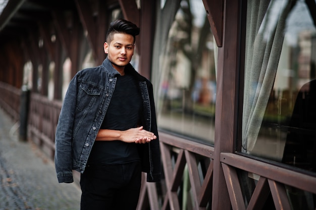 Handsome man in black jeans jacket posed outdoor