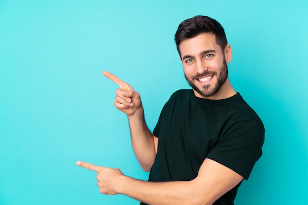 handsome man on blue pointing finger to the side and presenting a product