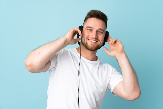  handsome man on blue wall listening music