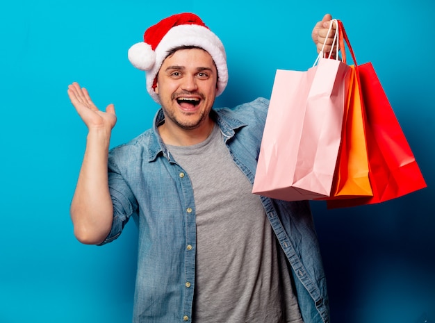 Handsome man in Christmas hat with shopping bags