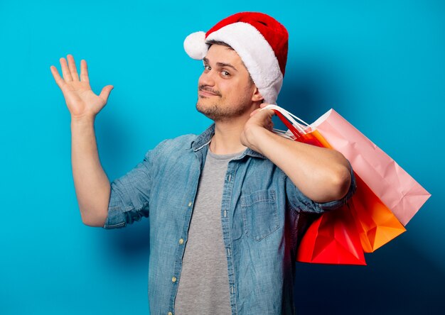 Handsome man in Christmas hat with shopping bags