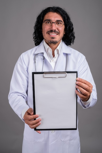 Handsome man doctor with mustache against gray wall