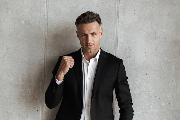 Handsome man dressed in suit showing his fist