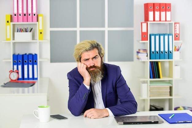 Handsome man drinking coffee from cup businessman sit in office work online on computer tired professional businessman at laptop business man wearing smart casual clothes