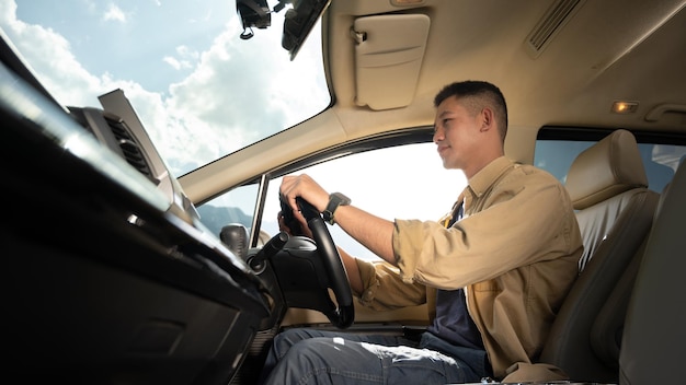 Handsome man driving car enjoying road trip on vacation Transport summer vacation and holiday