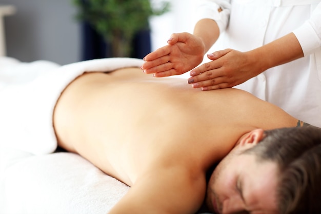 handsome man having massage in spa salon