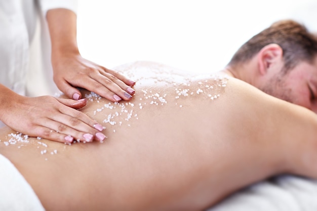 handsome man having massage in spa salon