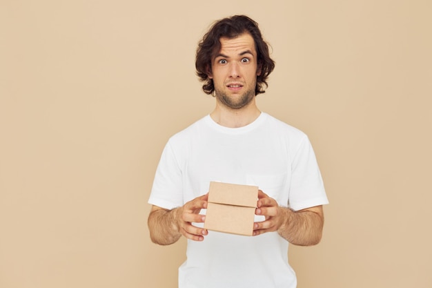 Handsome man holding a cardboard small box in his hands