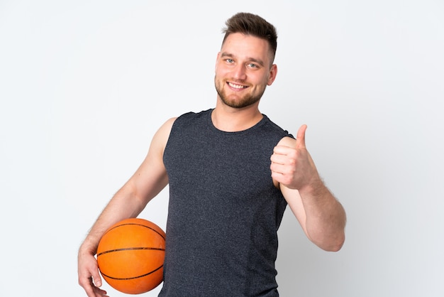 Handsome man isolated on white wall playing basketball and with thumb up