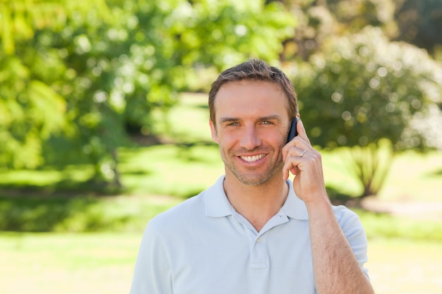 Handsome man phoning in the park