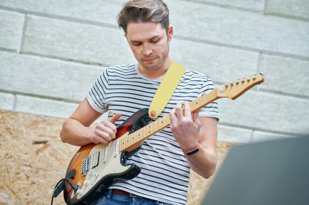 handsome man playing guitar in studio