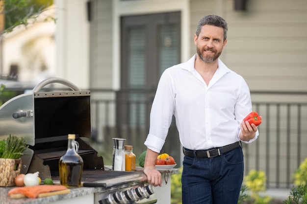 Handsome man preparing barbecue male cook cooking meat on barbecue grill guy cooking meat on barbecu