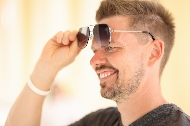 Handsome man rise glasses with his hand up from his eyes.