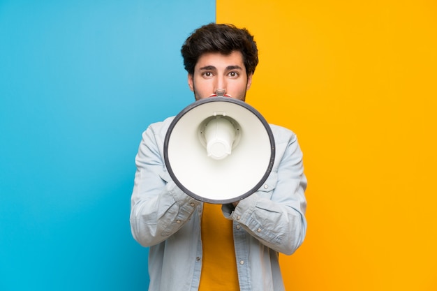 Handsome man shouting through a megaphone