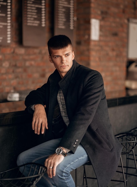 Handsome man sitting on a chair behind the bar