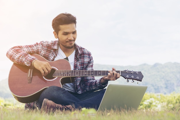 Handsome man smiling, playing guitar