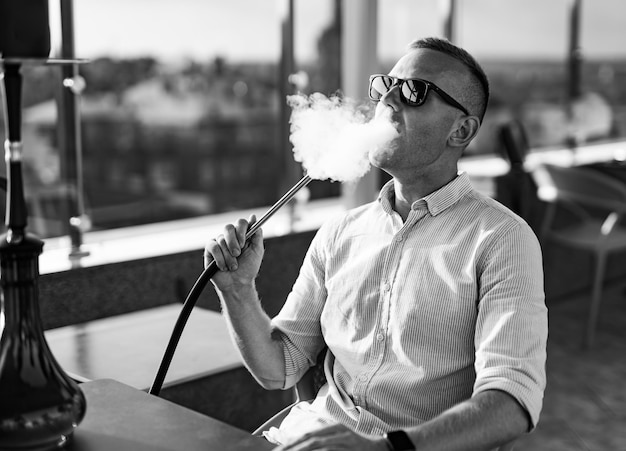 Handsome man smoking hookah Portrait of adult relaxing and smoking