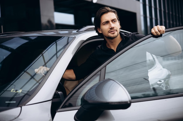 Handsome man standing by his new car