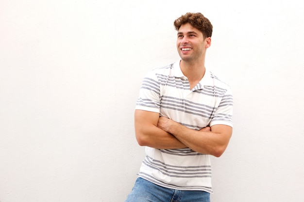 Handsome man standing and laughing with arms crossed