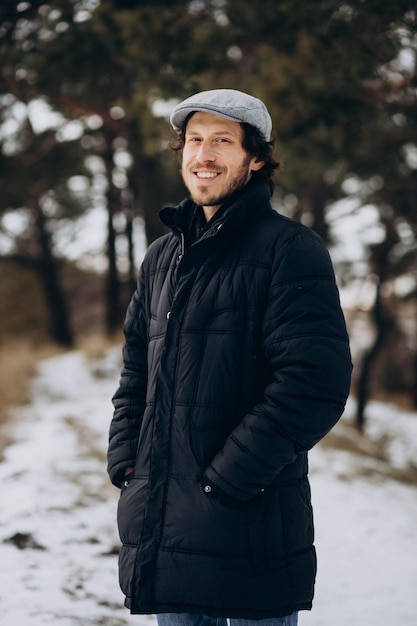 Handsome man standing in a winter park