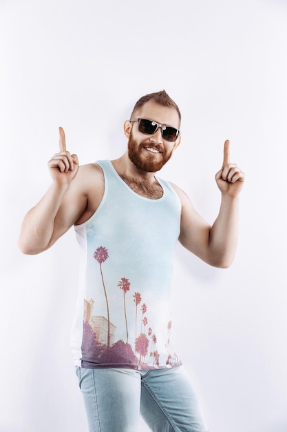 Handsome man in summer clothes amazed looking at camera and pointing with fingers and raised arms up